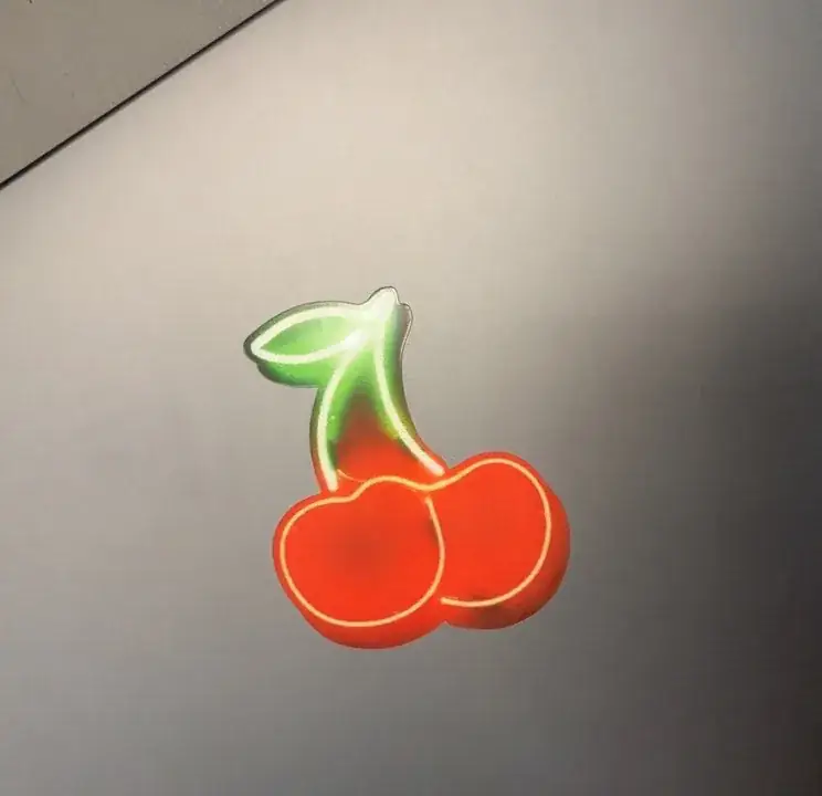 Reflective cherry custom sticker on a light-colored surface